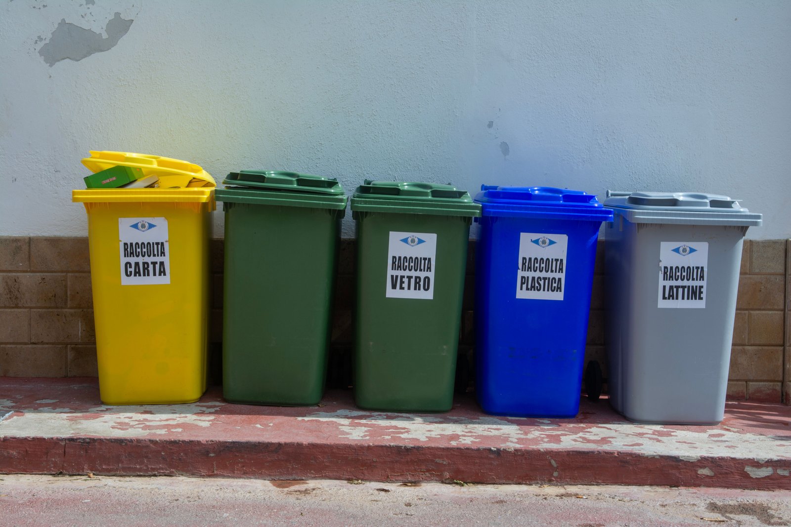 How to Prepare for a Full-House Cleanout Five colorful recycling bins organized for waste segregation in an urban setting.