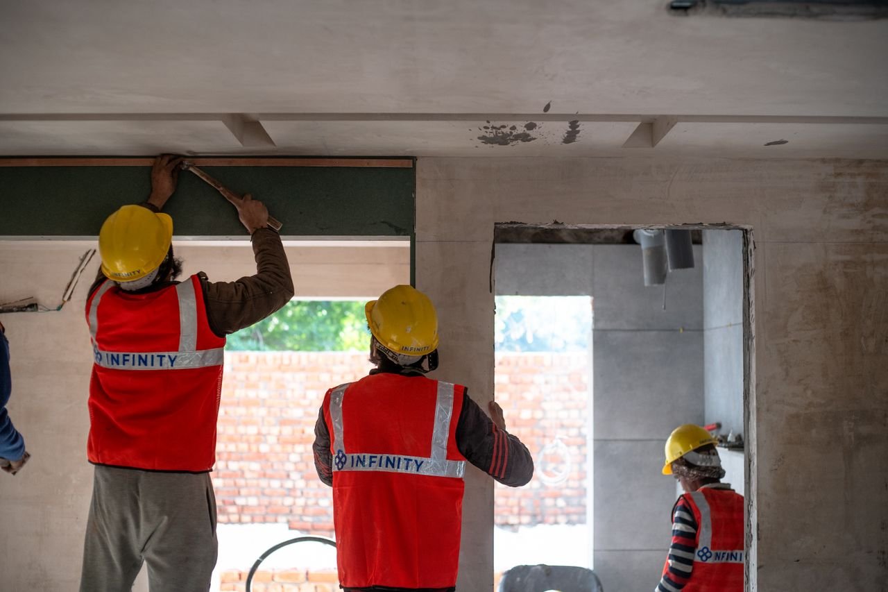 pexels photo 30592258 30592258 Construction workers renovating interior space in Delhi with safety gear and tools.